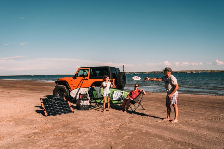 Family enjoying a beach day powered by their portable power station hooked to a solar panel