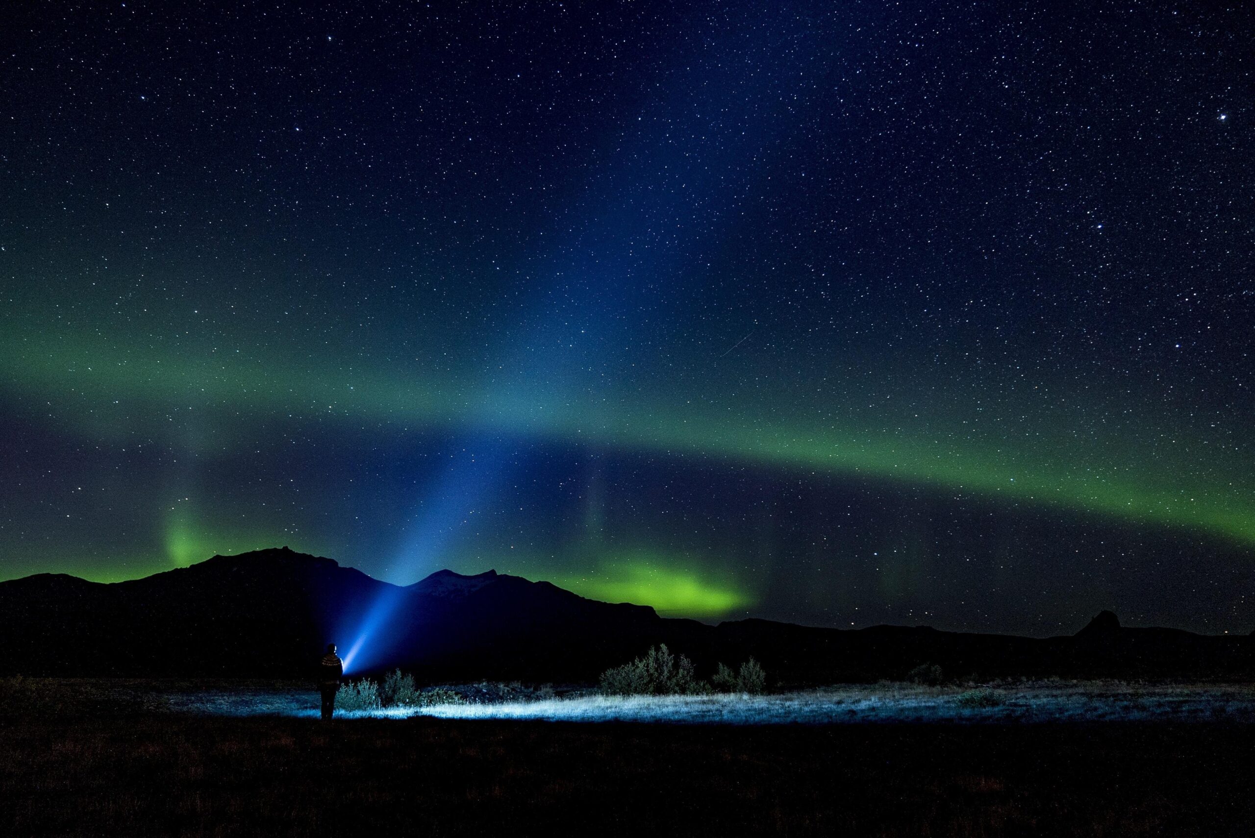 bright flashlight in field under stars